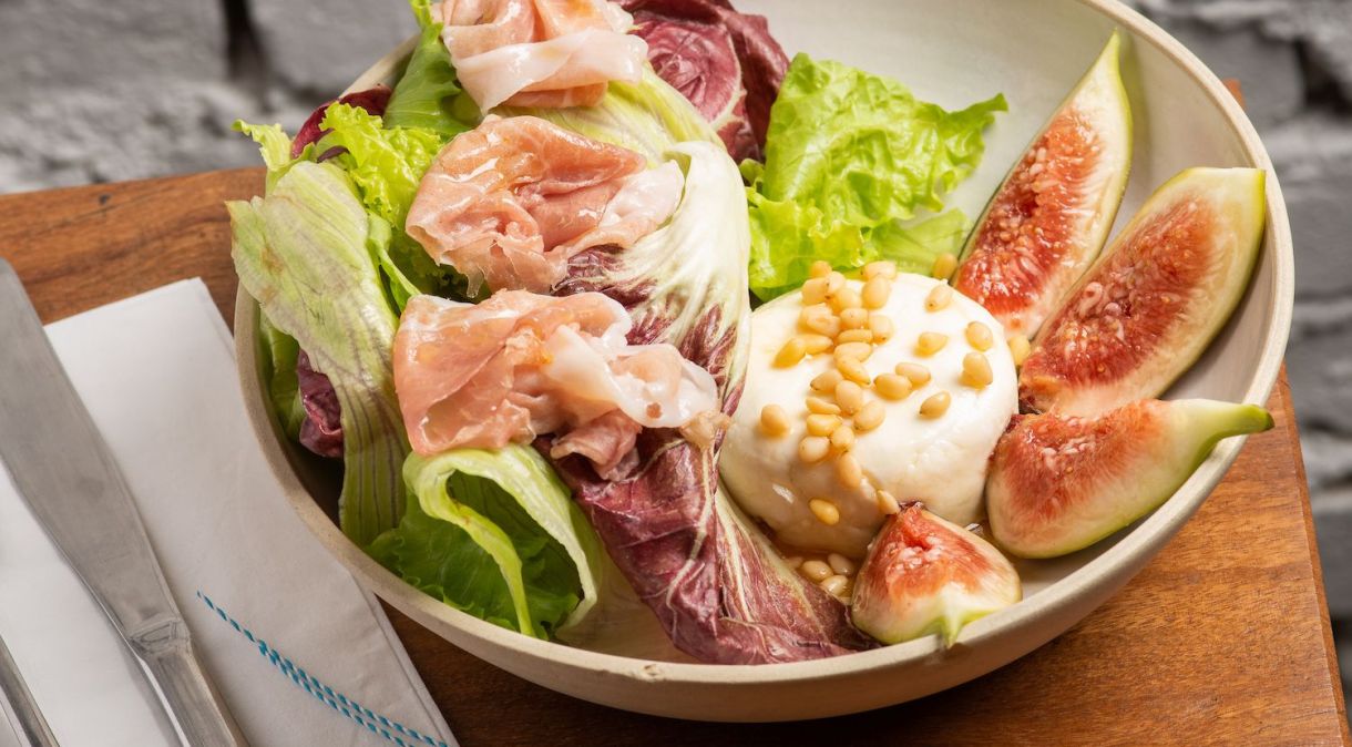 Salada feita com mix de folhas, queijo de cabra, presunto Parma, figo, mel orgânico e pinoli do restaurante grego Petros Greek Taverna
